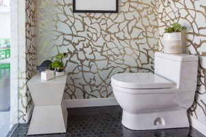 In the Vanessa de Vargas-designed powder room, which is accessible from inside the house as well as from the pool, the metallic wallpaper is by Jeff Andrews for Astek.